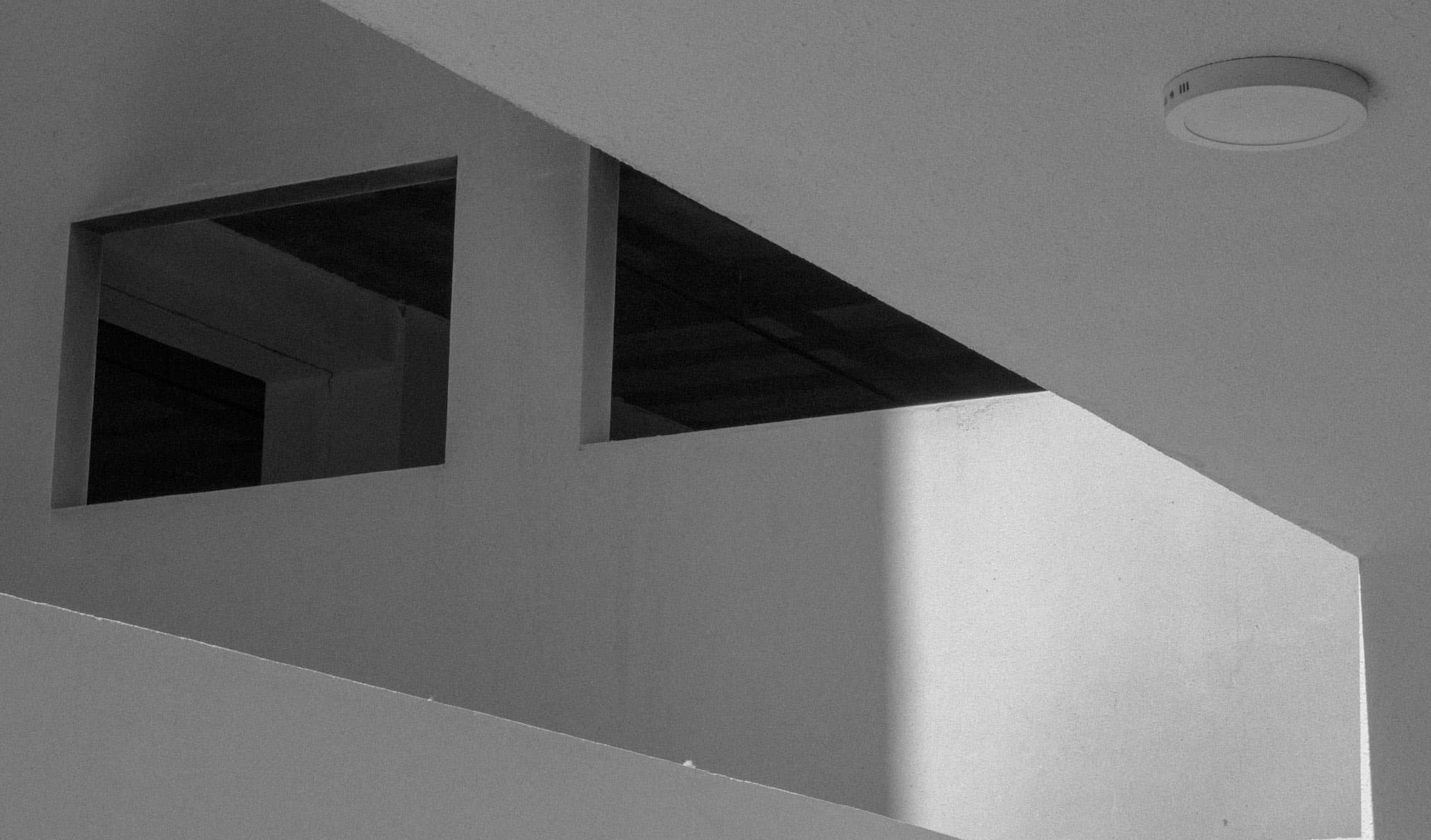 Sharp geometric openings cut into a white ceiling