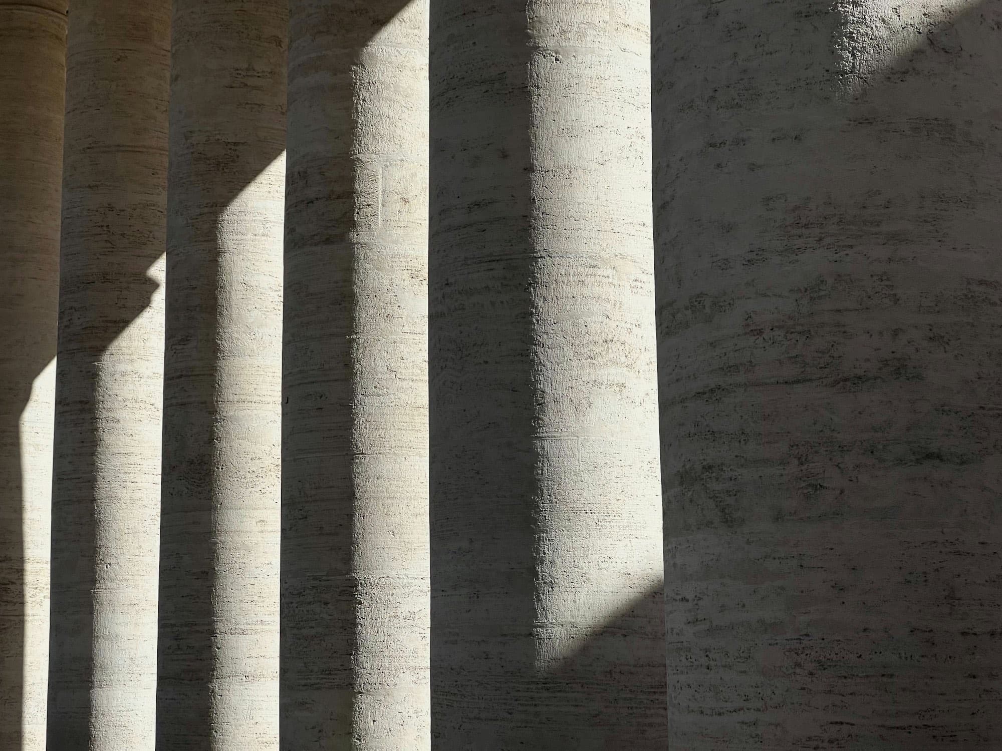 Raking daylight striping a wall of pale travertine